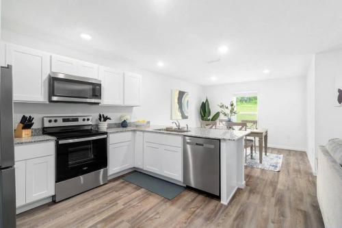 a kitchen with white cabinets and a black stove top oven at Springhill Retreat! 3 bed, 2 Bath! in Spring Hill
