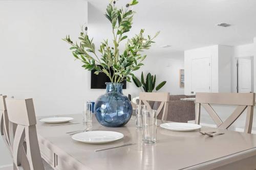 a table with plates and a blue vase on it at Springhill Retreat! 3 bed, 2 Bath! in Spring Hill
