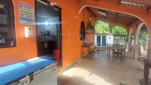Una cocina y un comedor con una pared naranja. en casavera, en Boca de La Honda
