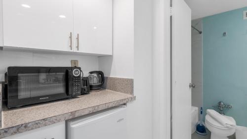 un microondas sentado en una encimera en una cocina en SeaStays ~ Oceanfront Apartments, en Miami Beach
