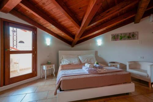 a bedroom with a bed and a window and a chair at Casa Nostra in Pula