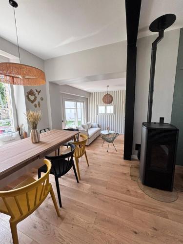 - un salon avec une table et un poêle à bois dans l'établissement Les oiselieres, plages a pieds, à Carnac