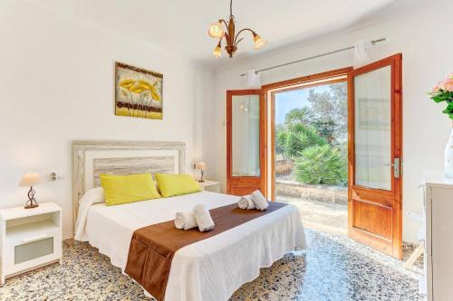 a bedroom with a bed with yellow pillows on it at Villa Oliver by Villa Plus in El Port