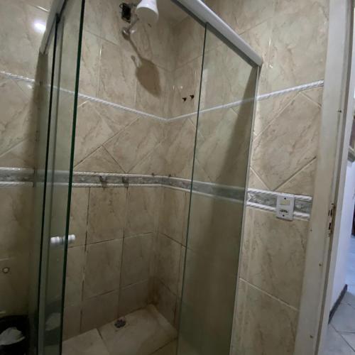 a shower with a glass door in a bathroom at Hostel ABC in Angra dos Reis