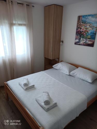 a bedroom with a bed with two towels on it at Apartmani Gaga in Tivat