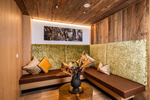 een kamer met een bank met een vaas op een tafel bij BEIM LOIS Edelweiss - AlpenLuxus Collection in Gerlos