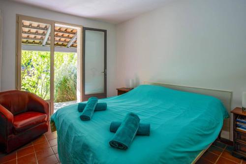 - une chambre avec un lit doté de draps bleus et d'une chaise dans l'établissement Villa Coeur de Provence by Villa Plus, à Saint-Savournin