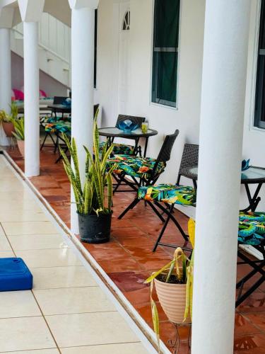 a patio with chairs and tables and tables at HCEAS villa is 5 min fr. airport & to the beaches in Bon Accord