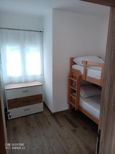 a small bedroom with two bunk beds and a dresser at Apartmani Gaga in Tivat