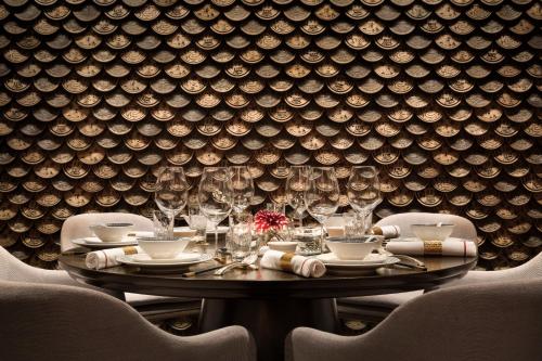 a table in a room with a wall of wine glasses at Shangri-La Eros New Delhi in New Delhi