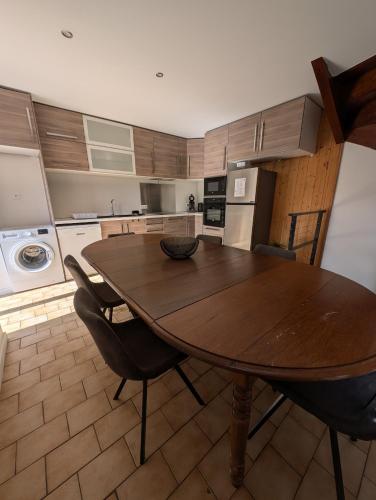 une cuisine avec une table en bois et quelques chaises dans l'établissement Maisonnette, à Villar-Saint-Pancrace