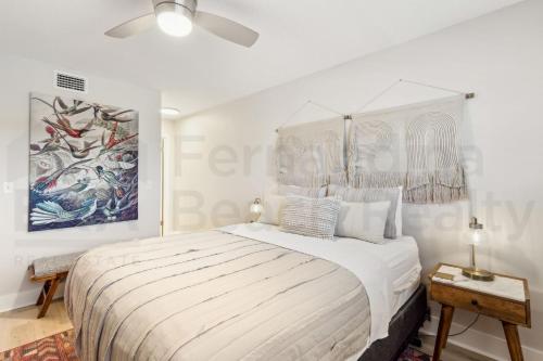a white bedroom with a large bed and a ceiling fan at Remodeled 2 Bed/2 Bath, 3rd floor Oceanfront condo sleeps 5. Oceanfront balcony & pool. in Fernandina Beach