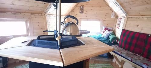 a table in a tiny house with a lamp on it at Dižozolu Rūķu nams in Dobeļžibali