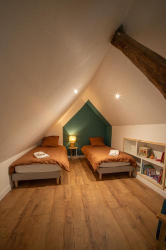 - 2 lits dans une chambre mansardée avec des murs verts dans l'établissement Appartement chaleureux le Grenier de Pommard, à Pommard