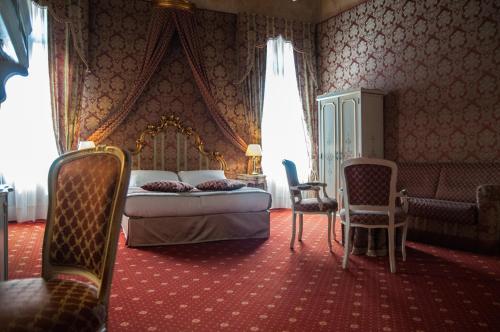 a bedroom with a bed and a couch and chairs at Ca' Amadi in Venice