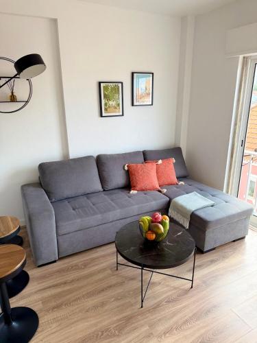 a living room with a couch and a table with a bowl of fruit at Ton's Loft 3 mins to the Beach in Costa da Caparica