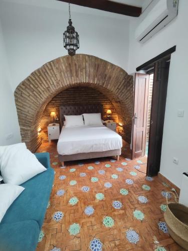 a bedroom with a bed and a couch at Home Sweet Casa de los Arcos Parking Free in Córdoba