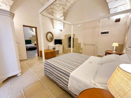 Un dormitorio con una cama grande y una habitación con en Masseria Lu Monaco, en Melendugno