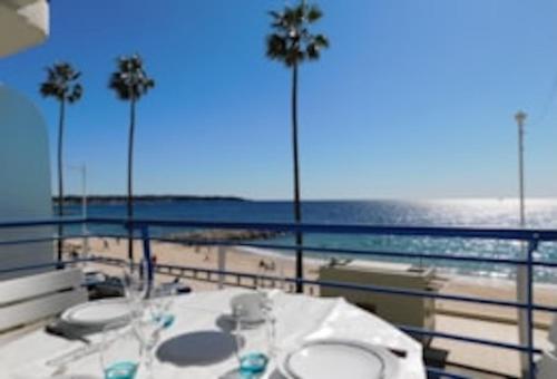 einen Tisch auf dem Balkon mit Blick auf den Strand in der Unterkunft La caravelle in Juan-les-Pins