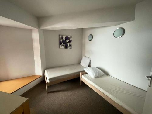 une petite chambre avec deux lits et un miroir dans l'établissement Résidence Balcon Du Canigou - T3 dans la résidence Les Balcons du Canigou MAE-4681, à Vernet-les-Bains