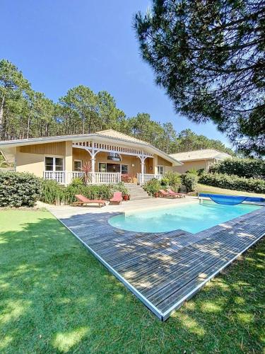 une maison avec une piscine dans la cour dans l'établissement Résidence Atlantic Green - Villa spacieuse avec piscine chauffée pour 6 personnes Lacanau Océan MAE-1011, à Lacanau