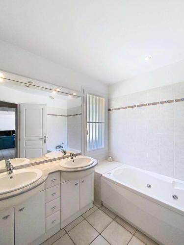 La salle de bains blanche est pourvue de 2 lavabos et d'une baignoire. dans l'établissement Résidence Atlantic Green - Villa spacieuse avec piscine chauffée pour 6 personnes Lacanau Océan MAE-1011, à Lacanau