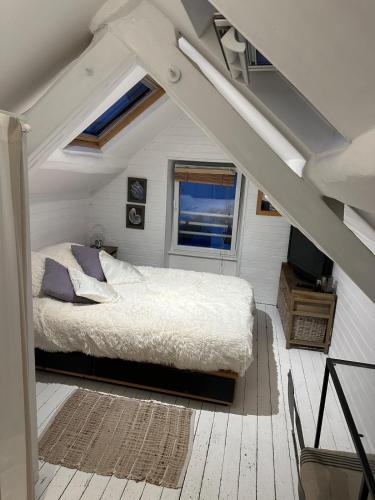 - une chambre avec un lit dans une pièce mansardée dans l'établissement Maison de pecheur Quiberon sea side, à Quiberon