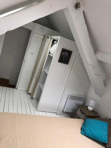 une chambre mansardée avec un lit et une étagère dans l'établissement Maison de pecheur Quiberon sea side, à Quiberon