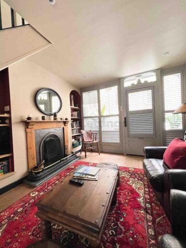 a living room with a coffee table and a fireplace at Old Bookshop - Unique house in central St Ives with outdoor space in St Ives