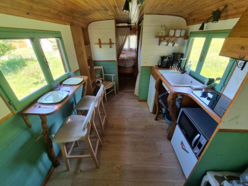 une salle de bain avec deux lavabos et un comptoir dans un train dans l'établissement Roulotte champêtre à la ferme, à Rochefort-Samson