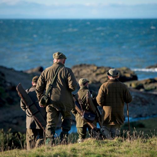 a group of men walking towards the ocean at Glenapp Castle in Ballantrae