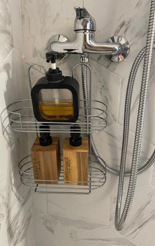 Un estante de baño con un dispensador de jabón en la pared. en Lever du soleil, en La Trinité