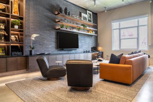 a living room with a couch and chairs and a television at Wynwood Condo, Walk to Restaurants and Nightclubs! in Miami