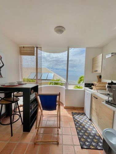 cocina con mesa, mesa y sillas en Lever du soleil, en La Trinité