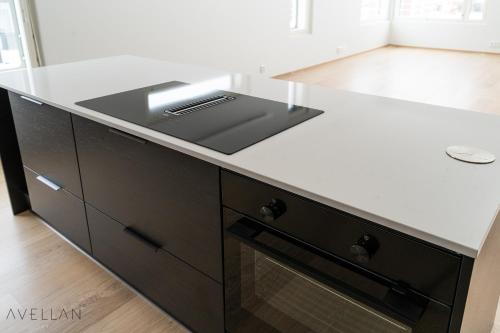 a kitchen with a white counter top and a stove at Come in! "Ilmatar" Luxury apartments in the heart of Tampere with yacuzzi option! in Tampere