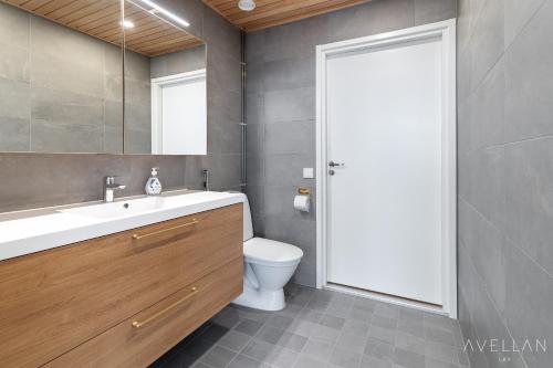 a bathroom with a sink and a toilet and a mirror at Come in! "Ilmatar" Luxury apartments in the heart of Tampere with yacuzzi option! in Tampere