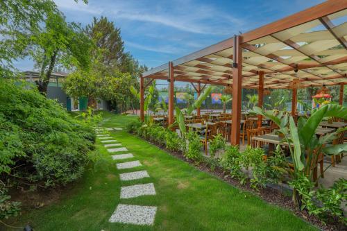 a patio with tables and chairs under a pavilion at Marbel Hotel by PalmWings in Kusadası