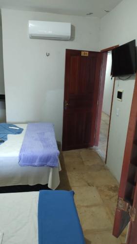 a small room with a bed and a door at Casa Aconchego Flecheiras in Trairi