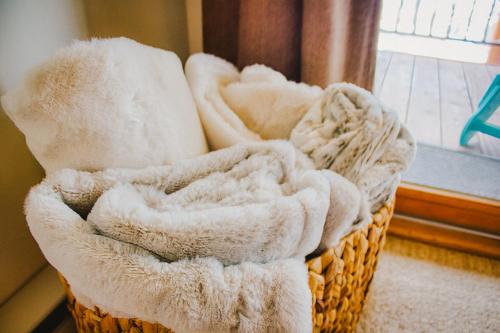 a basket filled with white towels next to a window at Highest Condo in CB with Stunning Views from Porch in Crested Butte