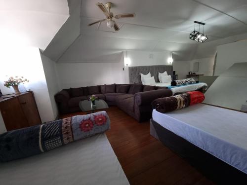 a living room with two beds and a couch at Ojong's Court Bellville in Cape Town