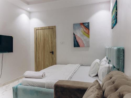 a small bedroom with two beds and a door at PLATINIUM 2Bedroom with PS5 & Pool in Lagos