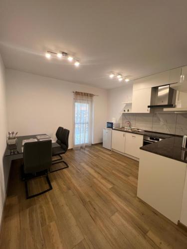 une cuisine avec une table et des chaises dans une pièce dans l'établissement Modern Apartman Szeged, à Szeged