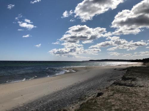 a beach with a cloudy sky and the ocean at Simrishamn, Österlen - privat boende med egen ingång in Simrishamn