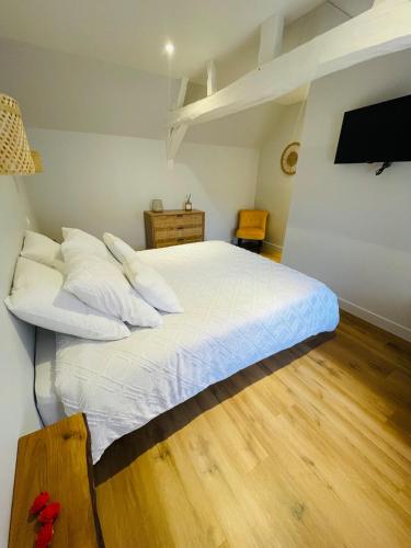 un lit avec des draps blancs et des oreillers dans une chambre dans l'établissement La Cabane, à Hesdin