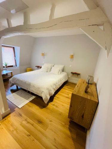 une chambre avec un grand lit dans un grenier dans l'établissement La Cabane, à Hesdin