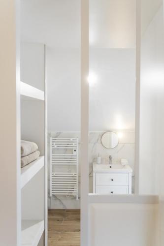 une salle de bain blanche avec un miroir et un lavabo dans l'établissement Pierres Blanches Guérande - Maison d'hôtes, à Guérande