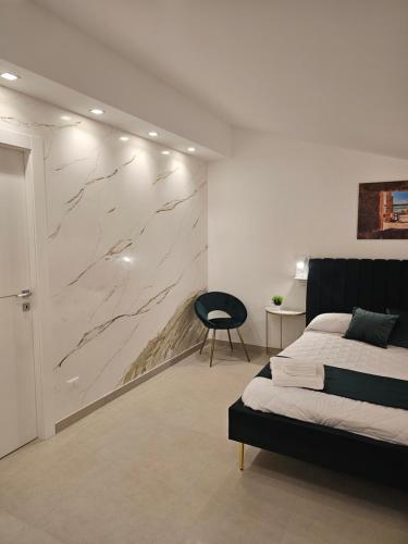 a bedroom with a bed and a marble wall at Aura B&B in Pachino