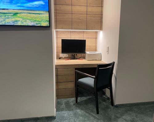 a desk with a computer and a chair in a room at PAULINEN Residenz in Detmold