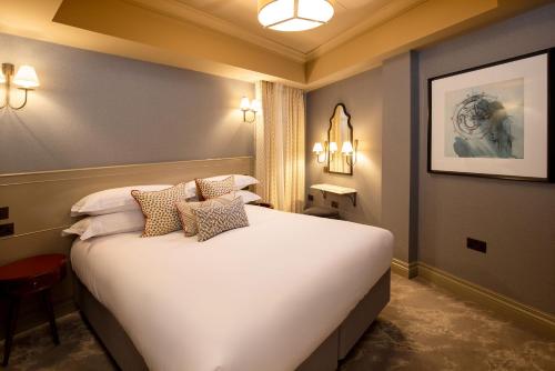 a bedroom with a large white bed in a room at The Capital Hotel, Apartments & Townhouse - Small Luxury Hotels of The World in London