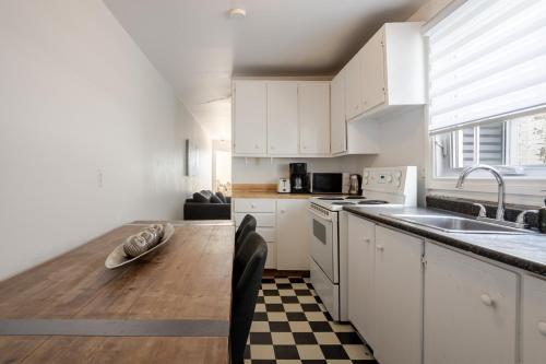 a kitchen with white cabinets and a wooden table at Bright 2BR in Plateau Mont Royal Downtown in Montréal